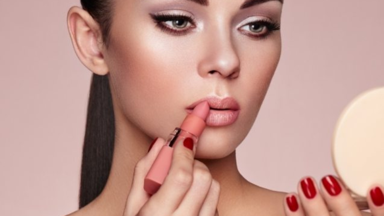 beautiful-woman-paints-lips-with-lipstick-PMB6YWP-1-637x478